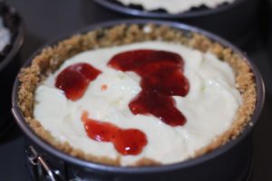Adding strawberry jam to Strawberry Swirl Mini Cheesecake @ bestwithchocolate.com