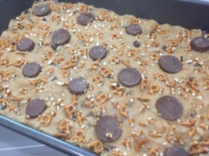 Pressing PB cups into pan for Peanut Butter Pretzel Bars @ bestwithchocolate.com