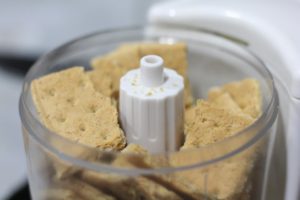 Crushing graham crackers for crust to Mini Cheesecakes @ bestwithchocolate.com