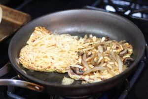 Grilling gouda cheese, pine nuts, and caramelized onions for Cauliflower Grilled Cheese @ bestwithchocolate.com