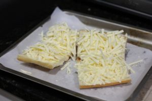 Topping with cheddar for Cheesy Garlic Bread @ bestwithchocolate.com