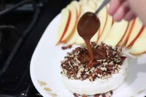 Dripping caramel over Caramel Apple Baked Brie @ bestwithchocolate.com