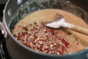 Adding chopped pecans to the icing for Praline Blondies @ bestwithchocolate.com