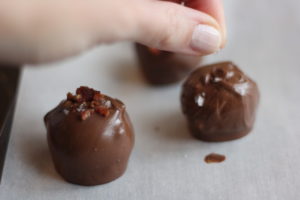 Sprinkling topping on Maple Bacon Truffles @ bestwithchocolate.com