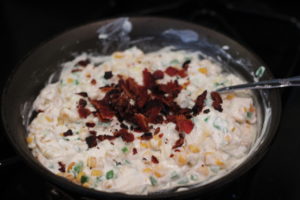 Crumbling bacon on top of Jalapeno Popper Dip @ bestwithchocolate.com