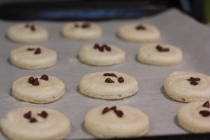 Topping macaroons with chocolate chips for Chocolate Chip Cookie Macaroons @ bestwithchocolate.com