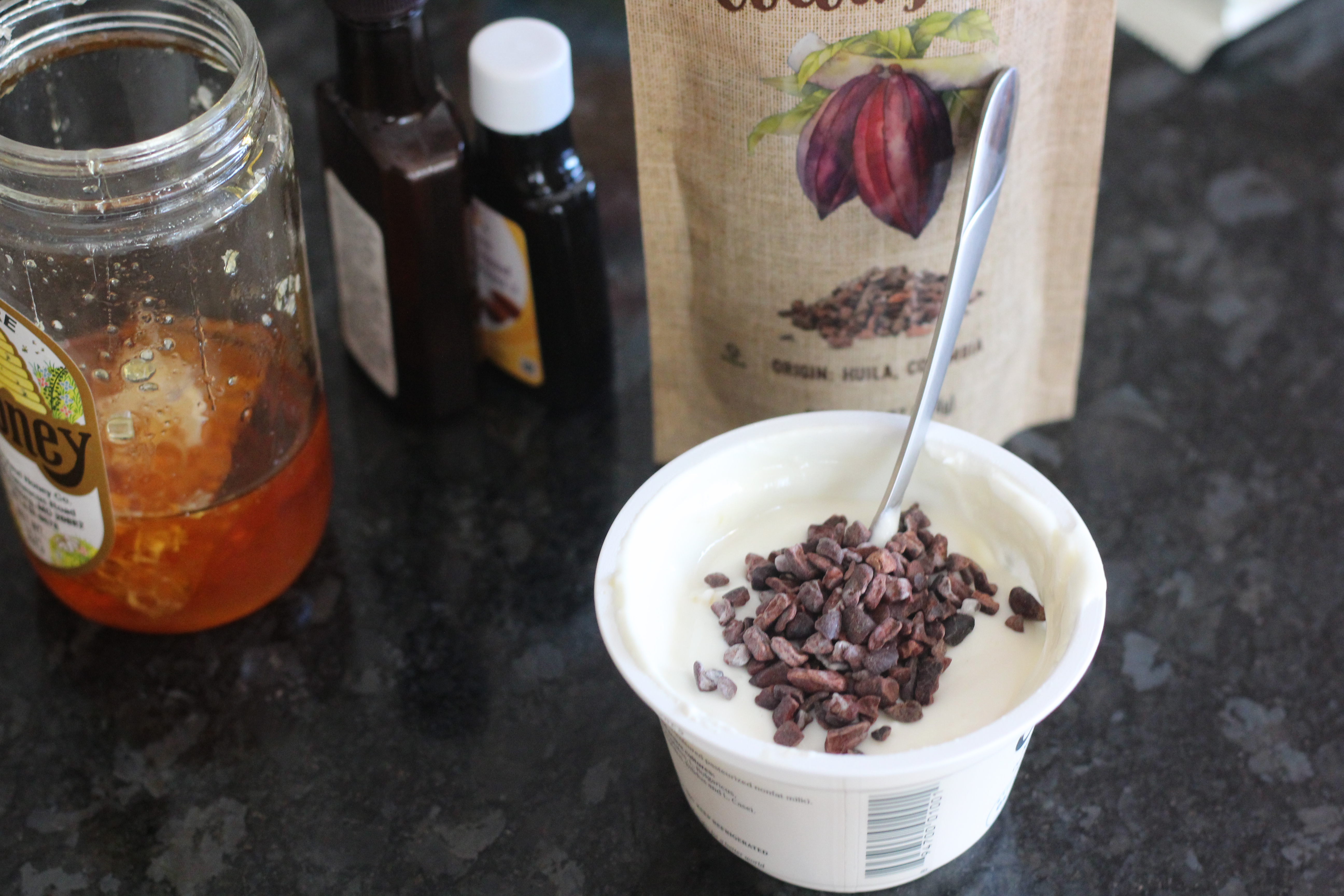 Adding cocoa nibs to cookie dough protein yogurt @ bestwithchocolate.com