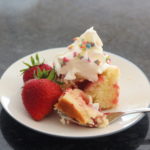 Strawberry sheet cake with fresh strawberries, whipped cream, and sprinkles