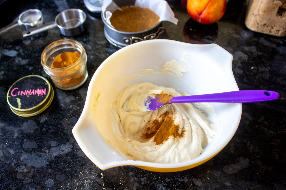 Mixing cinnamon into cheesecake batter for Peach Bouron Mini Cheesecakes @ bestwithchocolate.com