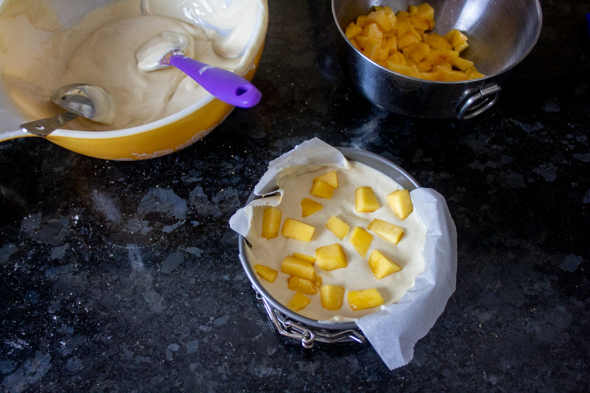 Adding peaches to Peach Bourbon Mini Cheesecakes @ bestwithchocolate.com
