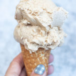 Hand holding ice cream cone with cinnamon ice cream