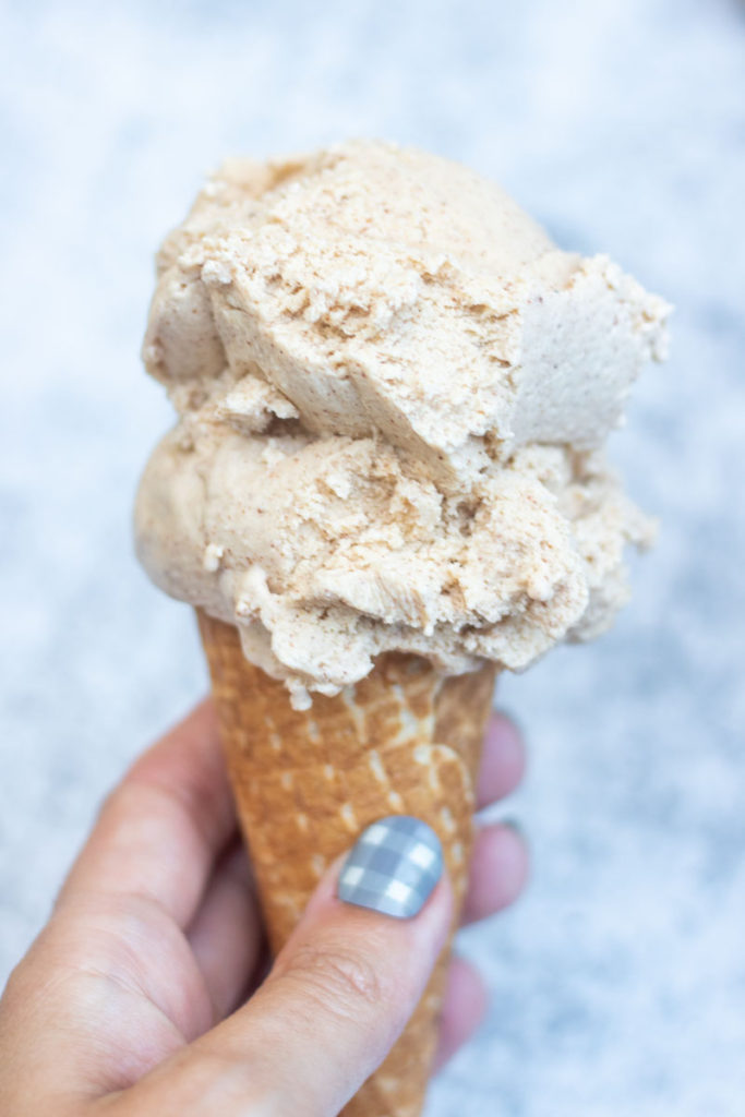 Hand holding ice cream cone with cinnamon ice cream
