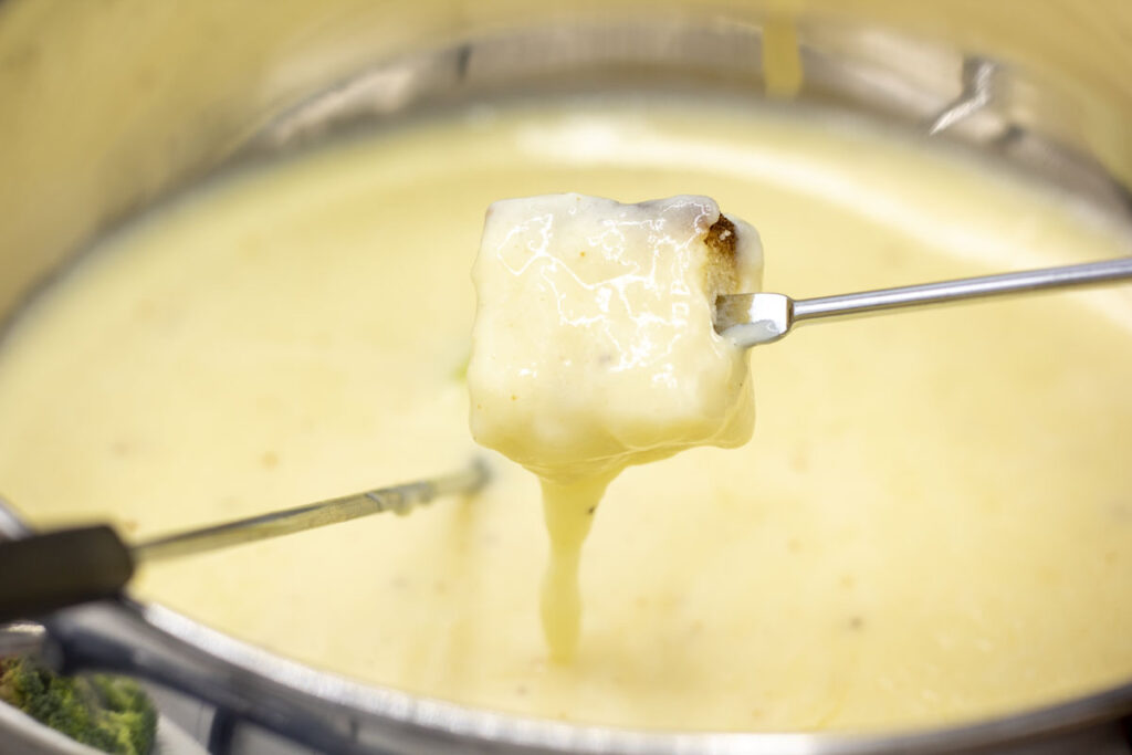 Dipping a cube of bread into alpine cheese fondue