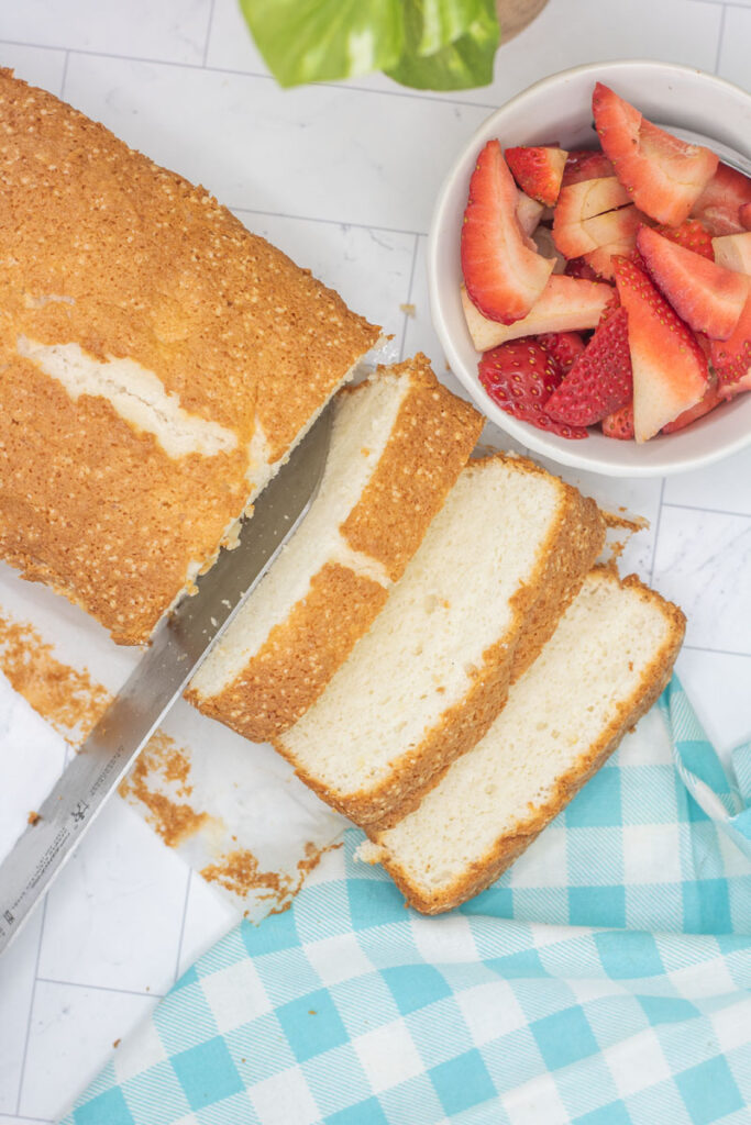 Knife slicing a loaf of angel food cake