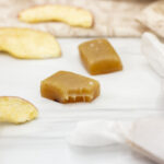 Apple cider caramels amidst wrapped caramels and dehydrated apple slices