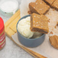 Biscoff blondie perched on a dish of vanilla ice cream