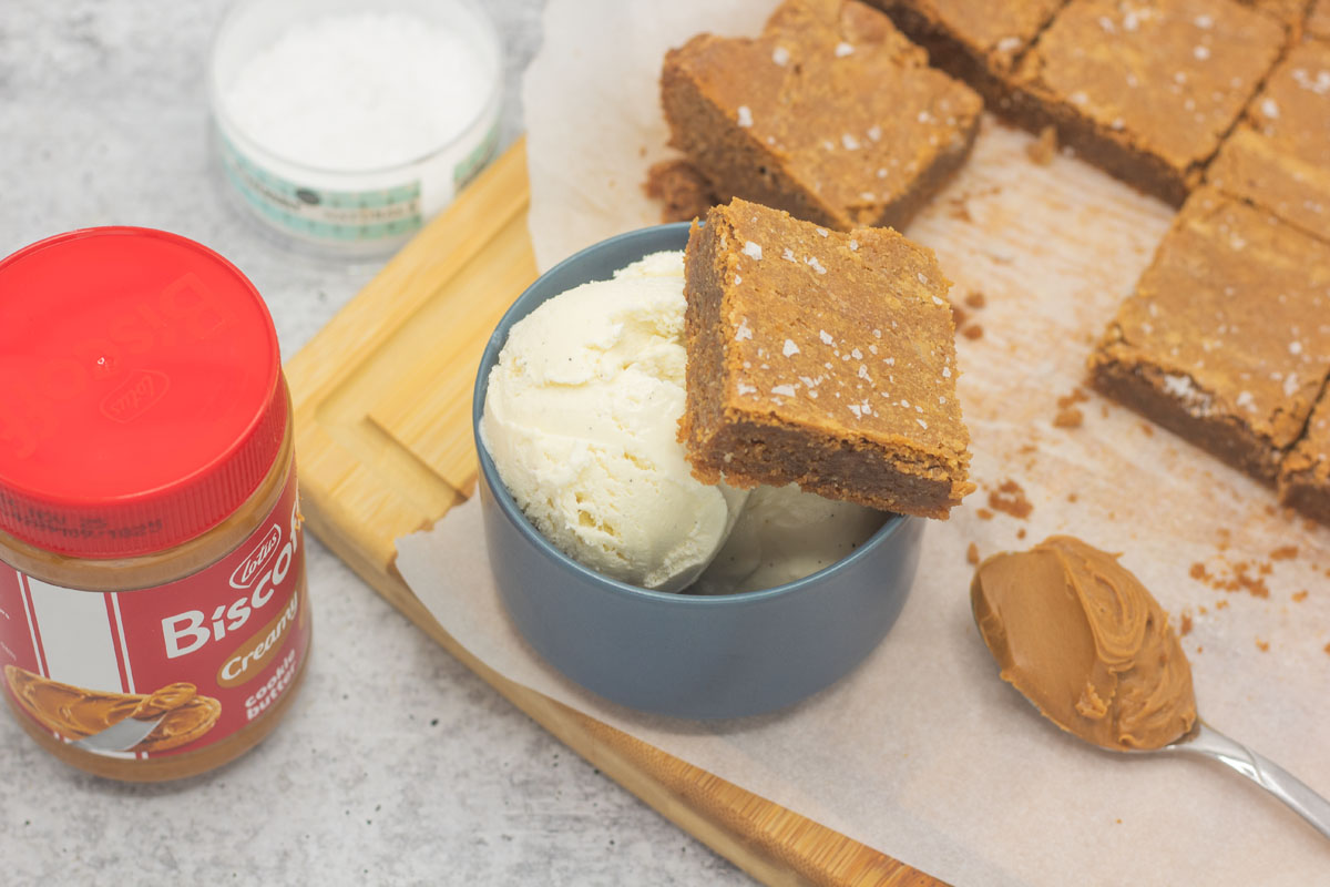 Biscoff blondie perched on a dish of vanilla ice cream