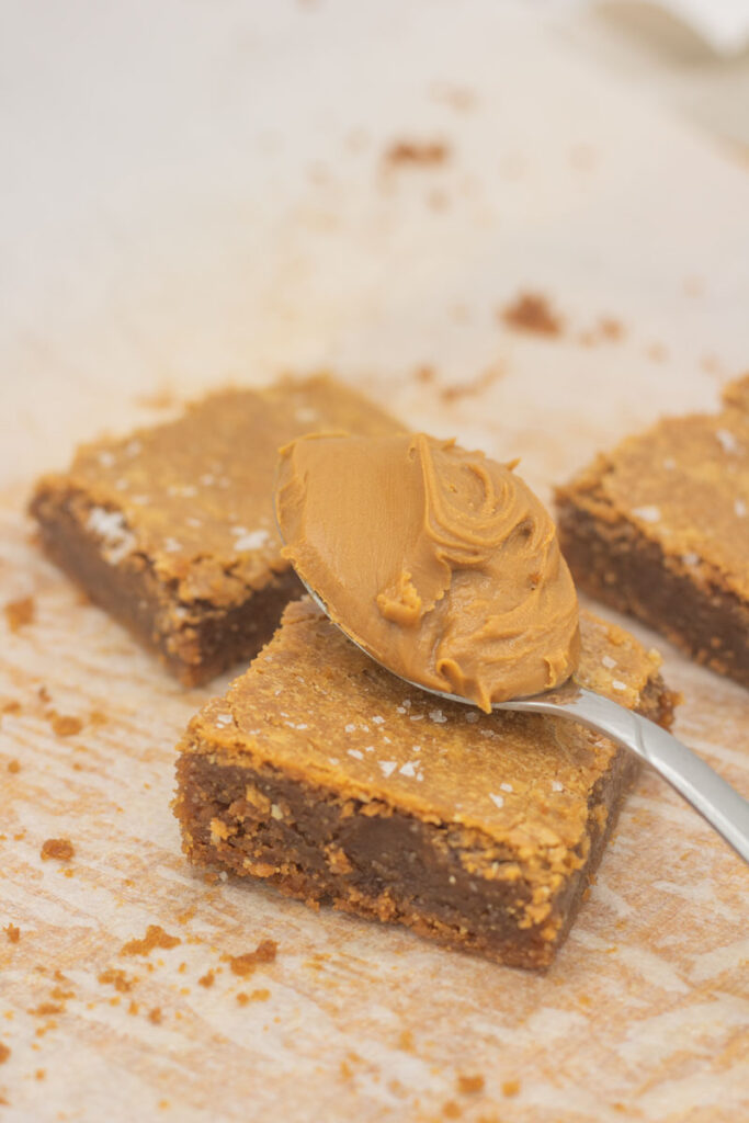 Spoon full of cookie butter on a biscoff blondie bar