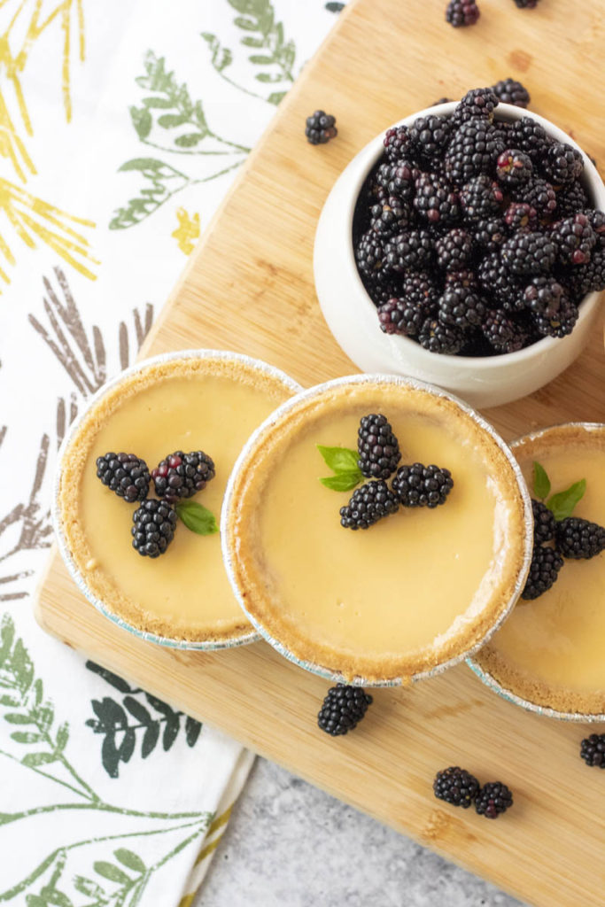 blackberry lime tarts with a bowl of wild blackberries