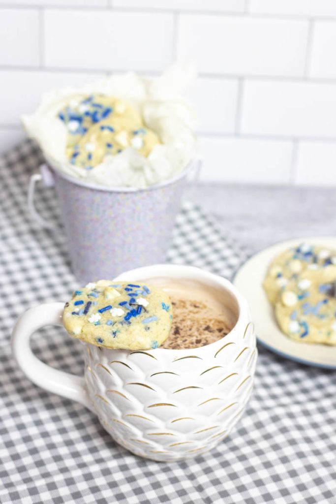blizzard cookies on a cup of hot chocolate and scattered around