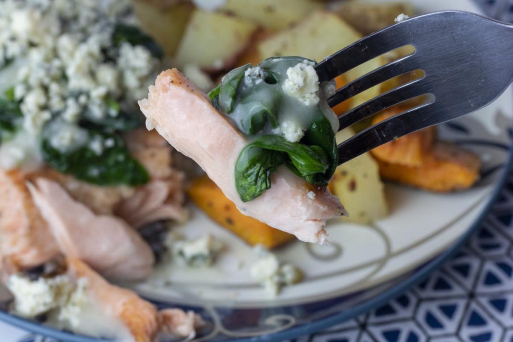 bite of lemon butter spinach blue cheese salmon on a fork