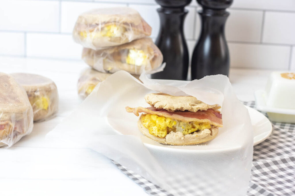 Meal prep breakfast sandwiches around a partially unwrapped bacon egg and cheese sandwich