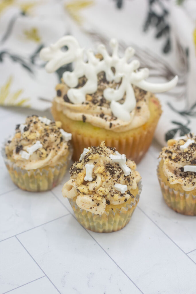 Dinosaur bone cupcakes and mini cupcakes with brown butter frosting and bone sprinkles