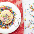 butter sprinkle cookie on a plate of sprinkles