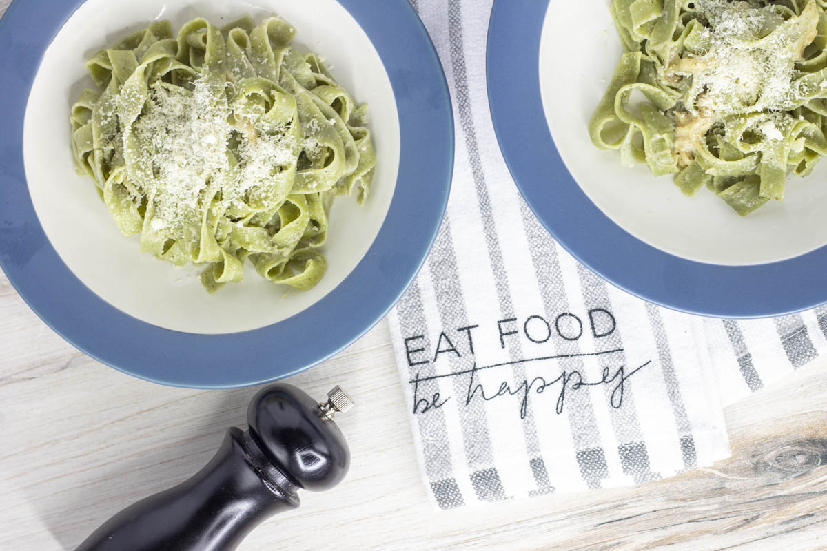 two bowls of pasta with a towel that says eat food, be happy