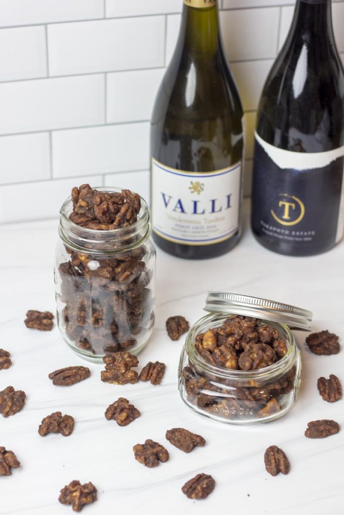 candied cinnamon nuts in a jar and scattered around