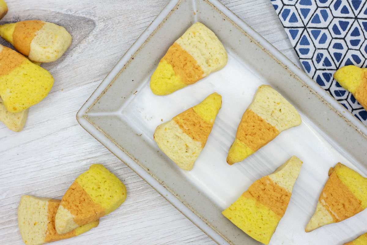 Orange, yellow and white candy corn cookies arranged on a plate