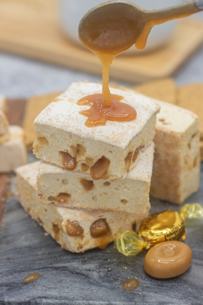 Spoon dripping caramel sauce on caramel crunch marshmallows