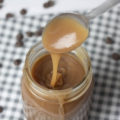 spoon drizzling salted caramel sauce into a mason jar
