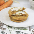 A stack of stuffed carrot cake cookies, the top one broken open