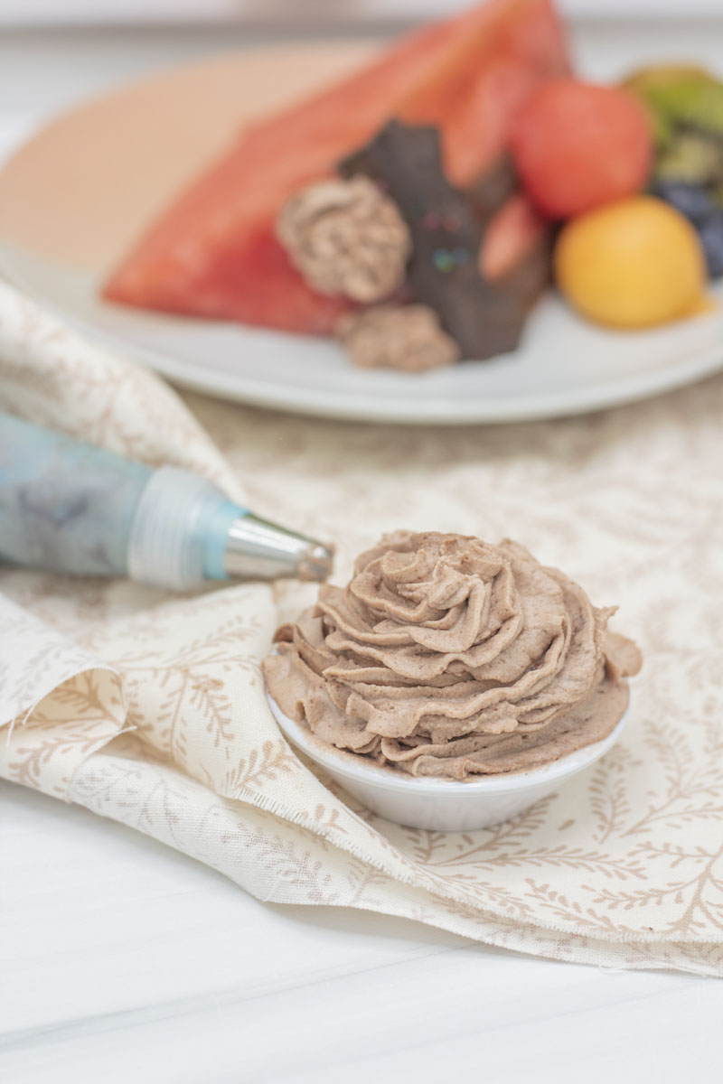 a bowl of whipped cream frosting on a table