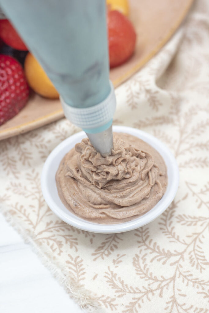 Piping stabilized whipped cream into a small dish