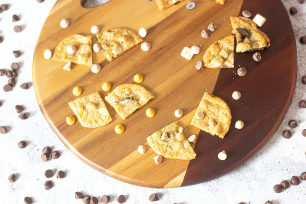 Specialty chips baked into cookies, pieces arranged on a wooden board