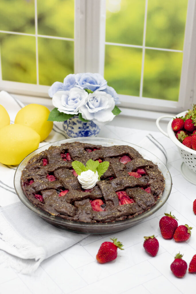 Chocolate lattice strawberry pie among lemons and scattered strawberries