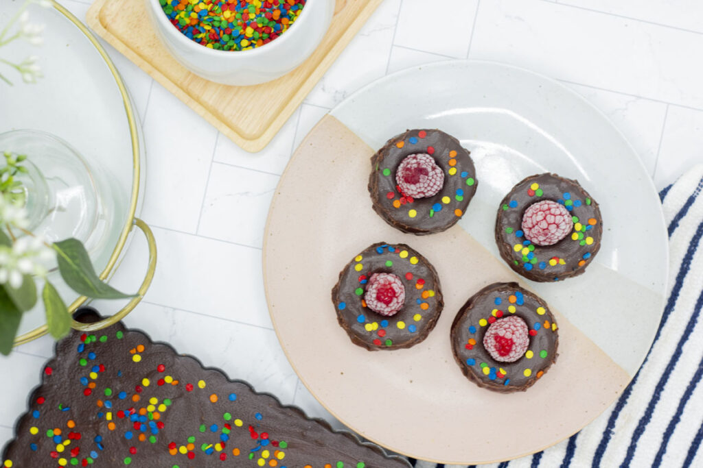 Assorted individual raspberry chocolate tarts and a chocolate tart in a tart pan