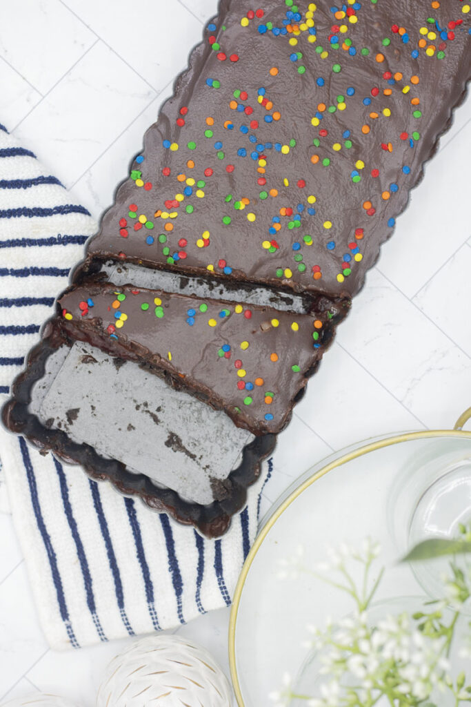 A slice of chocolate tart in a tart pan