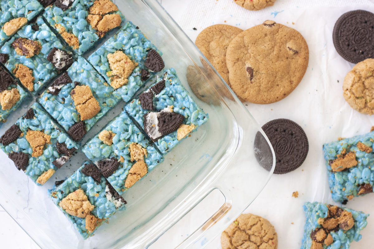 Tray of monster rice krispie treats with cookies scattered around