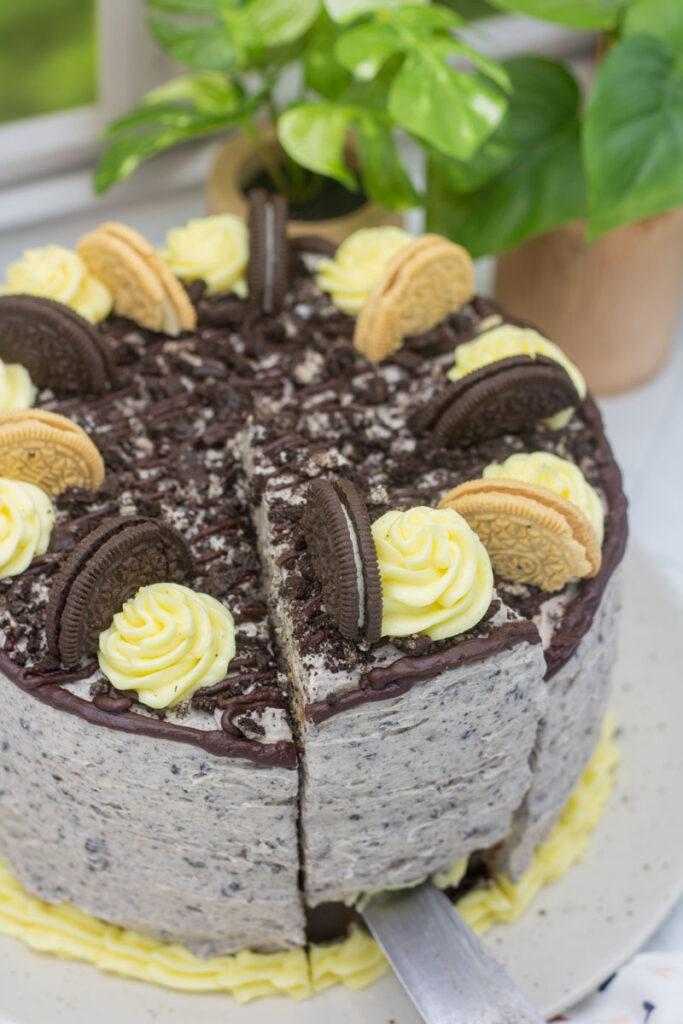 Knife lifting cake slice from cookies and cream cake