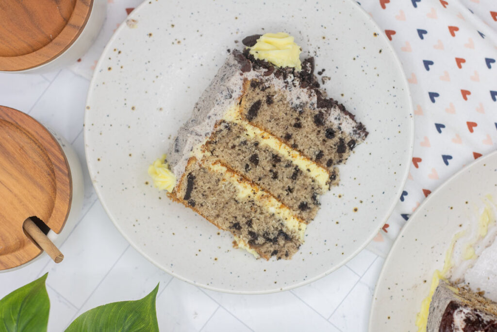 Slice of cookies and cream cake with cake batter filling and oreo frosting