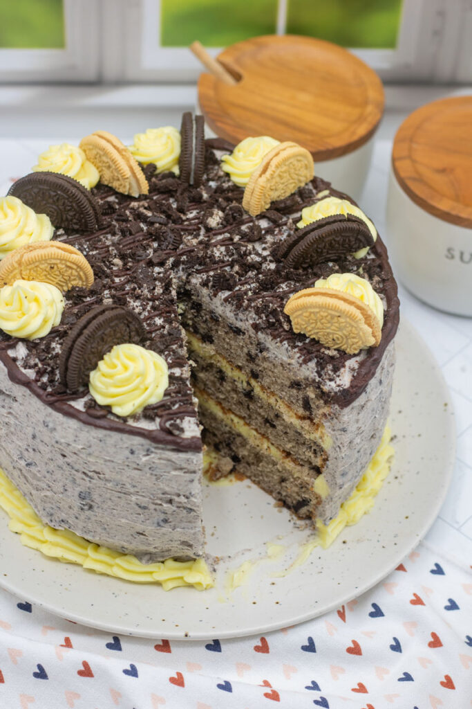 Slice taken from a cookies and cream cake decorated with oreos and buttercream