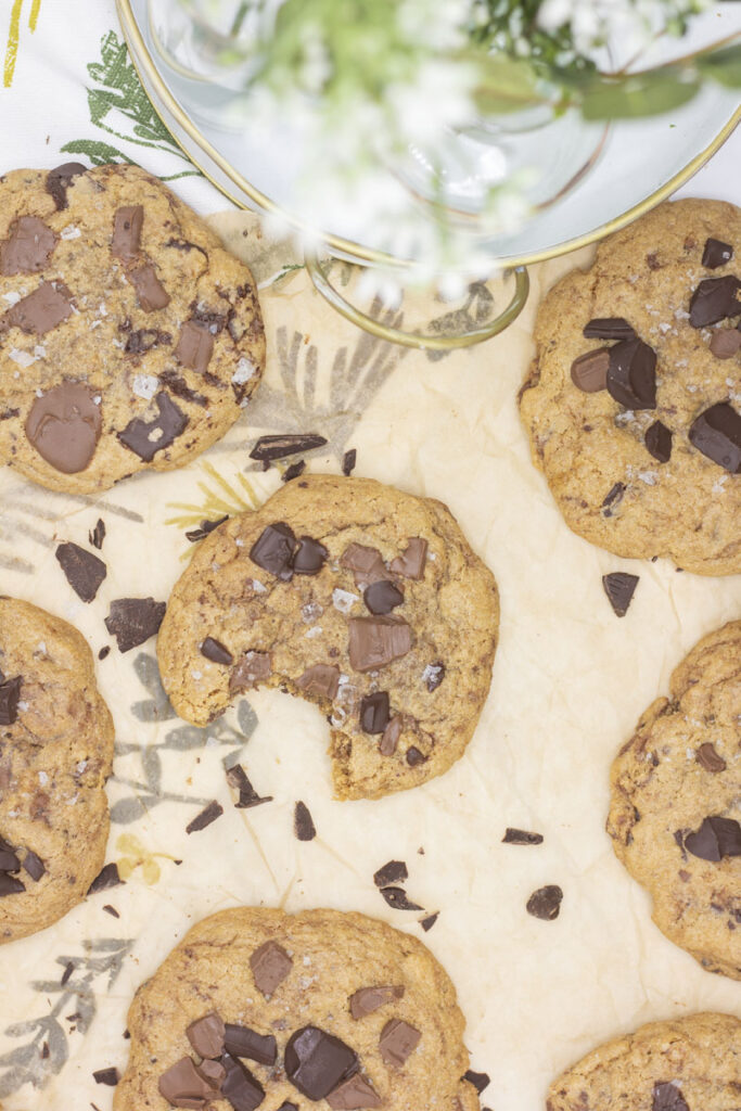 Scattered double chocolate chunk cookies on brown parchment paper