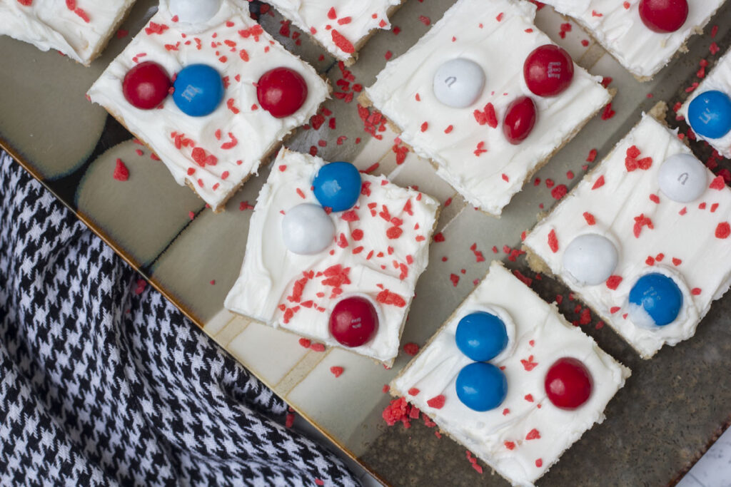 Squares of firecracker cookie bars topped with red, white, blue M&Ms and pop rocks