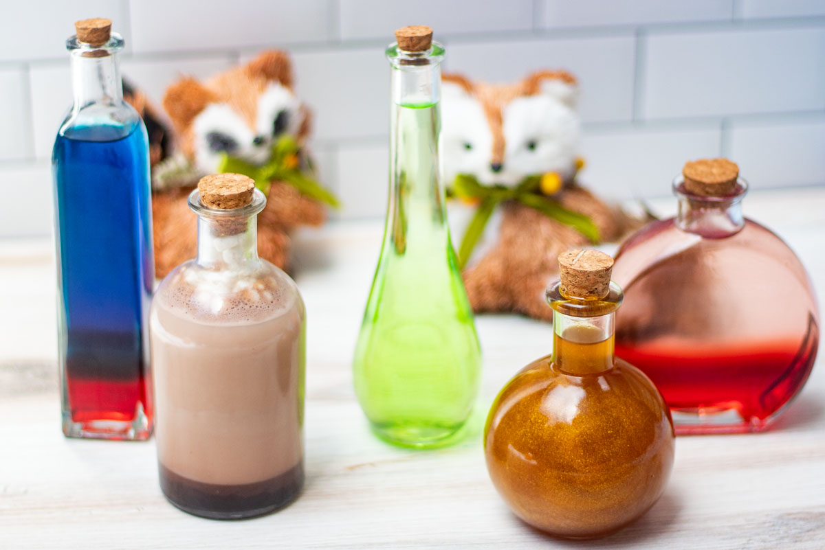 Five colorful halloween cocktails in varying potion bottles