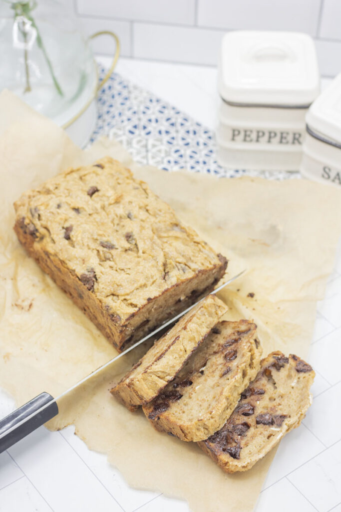 Knife slicing fresh chocolate chip banana bread