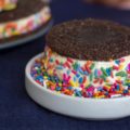 chocolate cookie ice cream sandwich on a plate of sprinkles