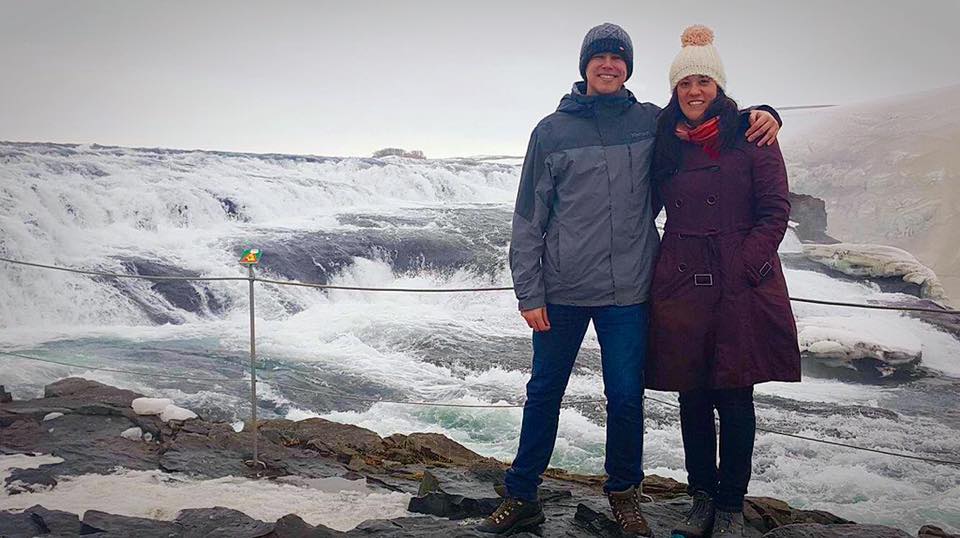 Two people in front of Gulfoss, a huger waterfall in Iceland